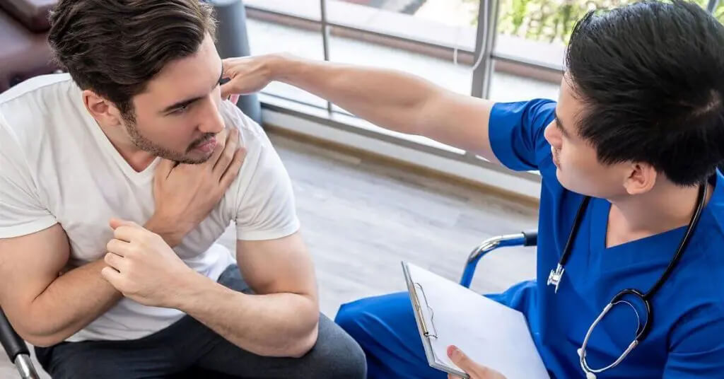 Doctor consulting with patient with shoulder pain